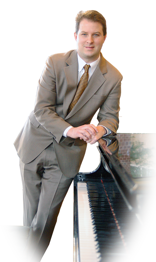 Picture of Michael Gray standing near piano